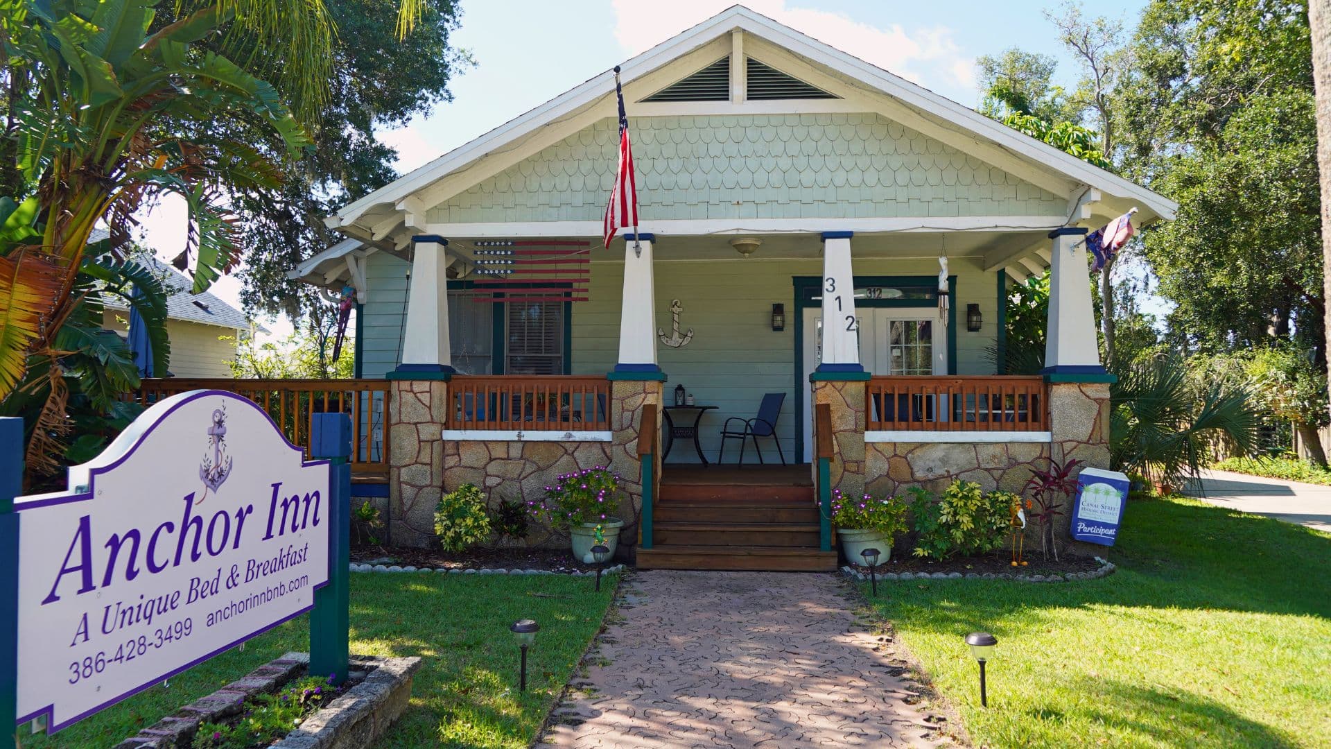 A charming bed and breakfast with a welcoming porch and colorful landscaping.